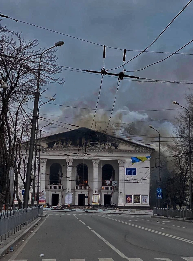 Обгоріла фасадна частина Драмтеатру з великим димовим шлейфом, що виходить з-під даху. ©Анонімний свідок